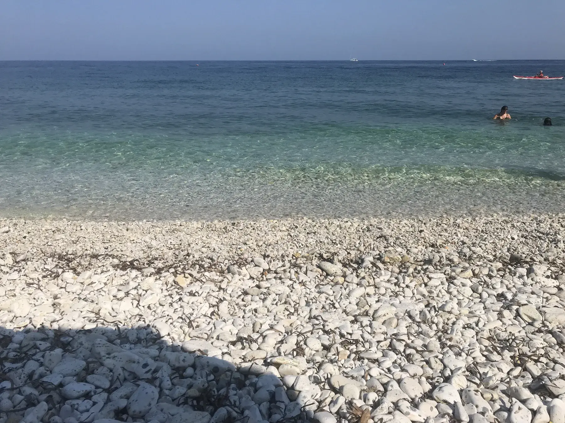 Ciottoli bianchi e acqua trasparente sulla spiaggia di Capo Bianco